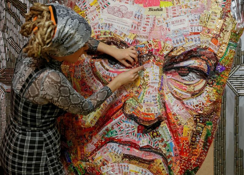 Artist Dariya Marchenko works on a portrait of Ukraine's President Petro Poroshenko named 'The Face of Corruption' which is made of wrappers from Roshen candies and empty shell cartridges brought from the frontline of a military conflct in Kiev. Reuters