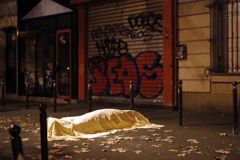 A victim under a blanket lays dead outside the Bataclan theatre in Paris on Nov 13, 2015, as more than 120 people were killed in a series of shooting and explosions across the French capital. Jerome Delay/AP Photo