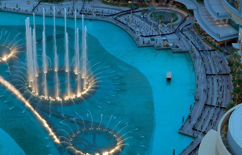 People observe social distancing while gathering to watch the Dubai fountain show in the UAE. AFP