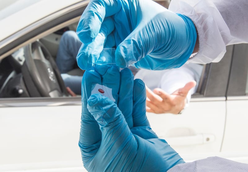 Dubai, United Arab Emirates - A passenger inside the car being tested by pricking blood sample before entering the Abu Dhabi at the new DPI Testing Centres border of Dubai and Abu Dhabi.  Leslie Pableo for The National for Shireena Al Nowais story