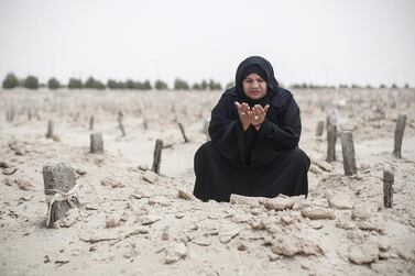 Sheikha Salem prays at her daughter’s grave in Baniyas. She quit a Government job to become a body washer. Mona Al Marzooqi / The National
