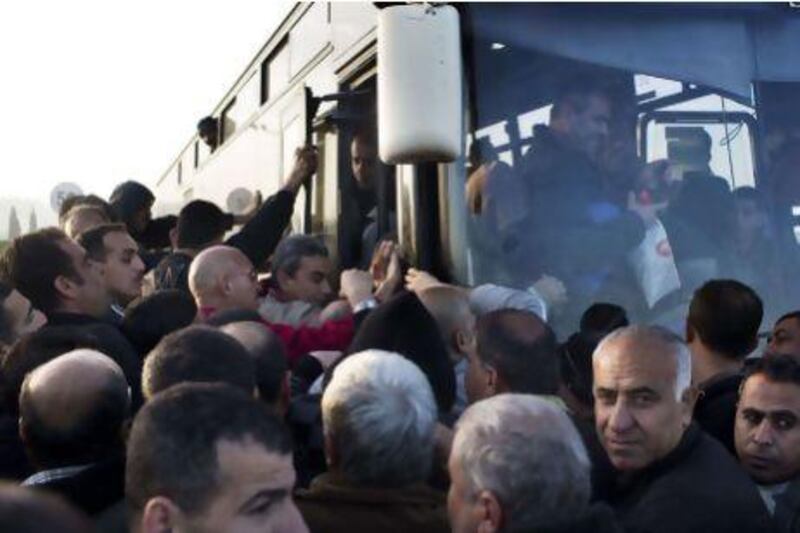 Palestinians board a Palestinians-only bus at the Eyal checkpoint, near the West Bank town of Qalqilya, on Monday. Menahem Kahana / AFP