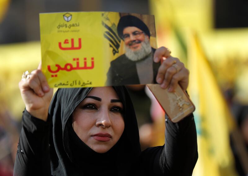 FILE - In this April 13, 2018, file photo, a supporter of Hezbollah leader Sayyed Hassan Nasrallah holds up his portrait with Arabic words that read: "We belong with you," during an election campaign speech in a southern suburb of Beirut, Lebanon. The Lebanese Hezbollah group has strongly rejected the British government's move to ban the group as a "terrorist organization." (AP Photo/Hussein Malla, File)