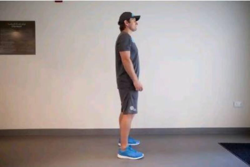 Stand with your feet shoulder-width apart, with your feet and knees pointing outwards. Look forward at eye-level and consciously activate your core (all the muscles in your mid-section, including your back and sides). Lee Hoagland / The National