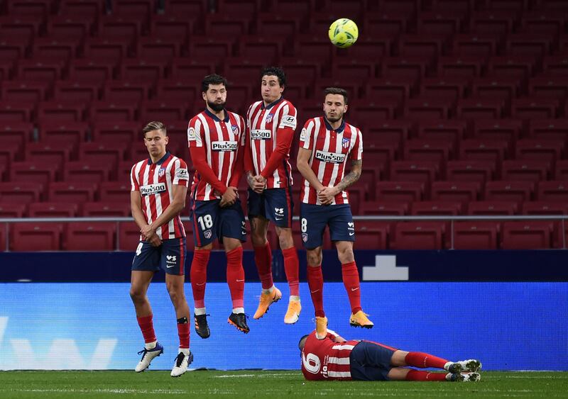 Marcos Llorente, Felipe and Saul Niguez jump to defend a free-kick. Getty