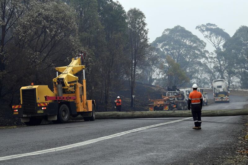 Workers replacing utility poles following bushfires in the outskirts of Quaama in Australia's New South Wales state.   AFP