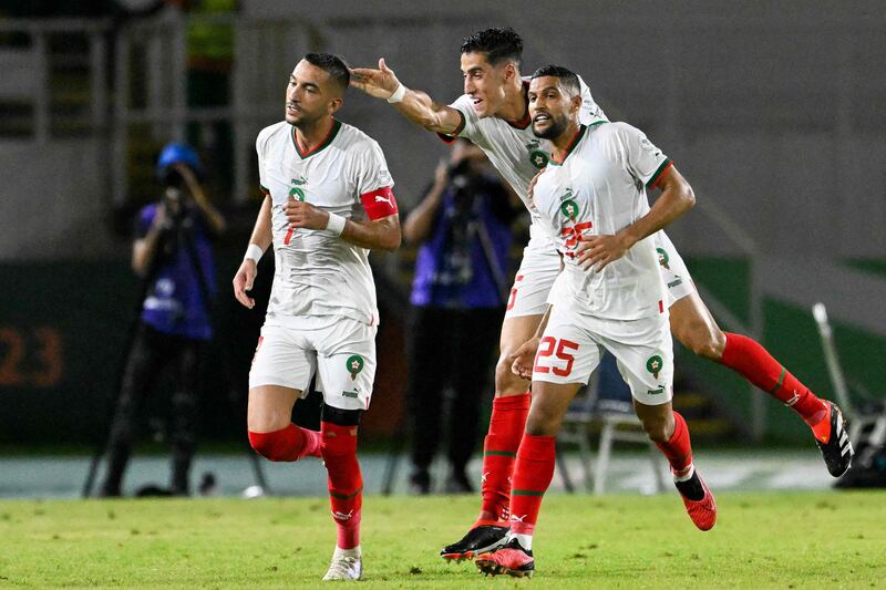 Morocco's Hakim Ziyech, left, celebrates with Nayef Aguerd and Yahya Attiat Allah after scoring his team's first goal against Zambia. AFP