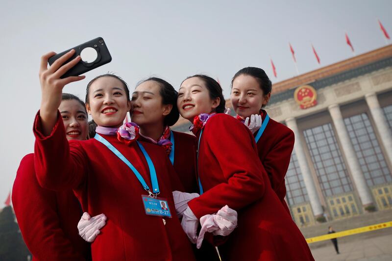 Hospitality staff members pose for a selfie outside the Great Hall of the People during a plenary session of China's National People's Congress (NPC) in Beijing. Andy Wong / AP Photo
