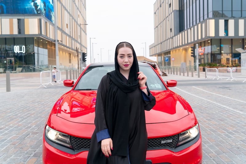 Car influencer Bayan Homsi with her red Dodge