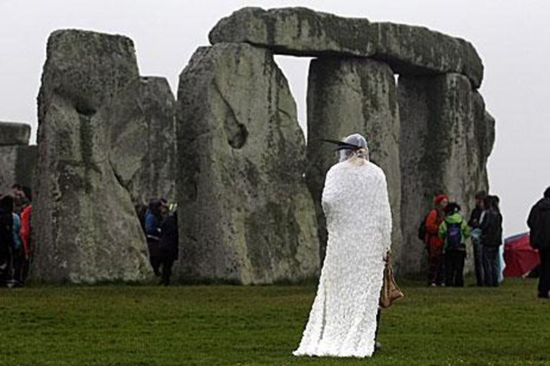 Gleu Sunpooja stands in front of Stonehenge as solstice revellers celebrate the arrival of the midsummer sunrise at the megalithic monument near Salisbury, England.