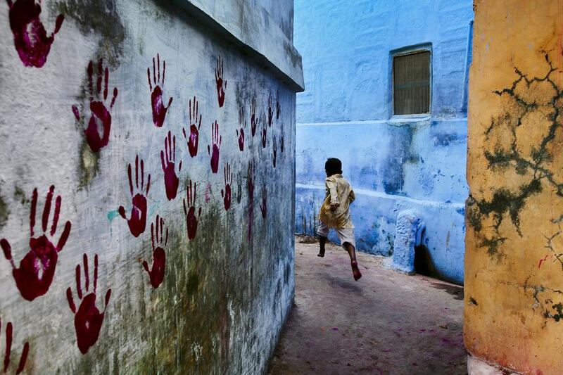 A young boy dashes through the narrow alleyways of Jodhpur, Rajasthan, in India, 2007.