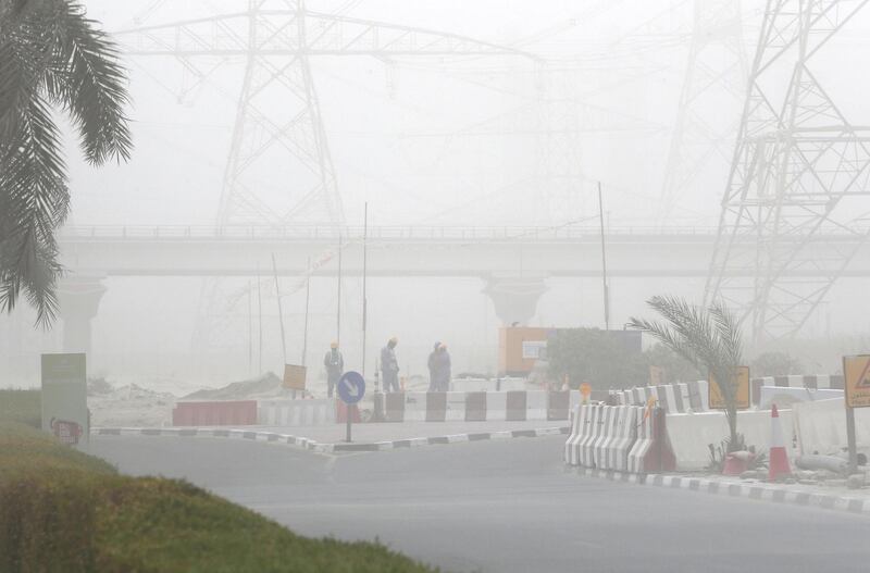 DUBAI, UNITED ARAB EMIRATES , July 21 – 2020 :- Labour working during the sandstorm in Discovery Gardens area in Dubai.  (Pawan Singh / The National) For News/Standalone/Online/Stock