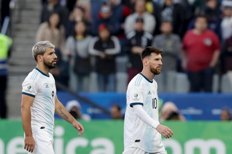 Argentina's Sergio Aguero, left, watches teammate Messi leaving the field after his red card. AP Photo