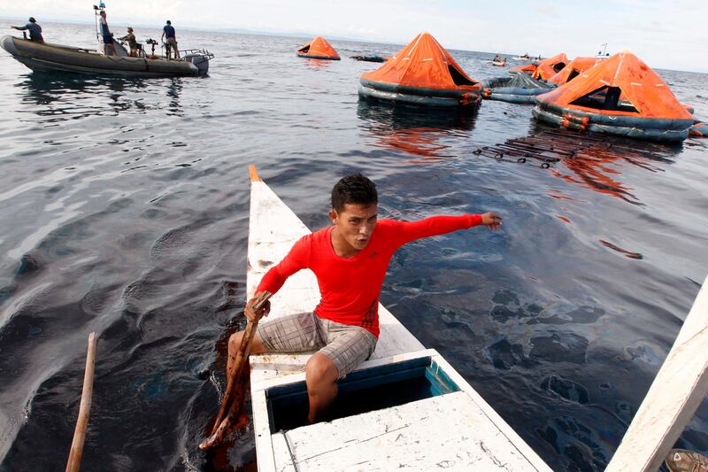 epa03827744 A Filipino fisherman in front of  floating life rafts used by passengers after a ferry accident  at  the  waters off Talisay City, Cebu province, central Philippines, 17 August 2013. The death toll in a ferry sinking in the central Philippines rose to 35 as rescuers searched for more than 200 still missing , the military said. Emergency workers have rescued 630 people from the waters off Talisay City in Cebu province, 580 km south of Manila, where the MV St Thomas of Aquinas sank on the evening of 16 August after colliding with a cargo ship.The coast guard said 870 people were on board the ferry. But the ship's owner said only 841 people were on its initial manifest. The vessel has an authorized capacity of 1,010.  EPA/DENNIS M. SABANGAN *** Local Caption ***  03827744.jpg