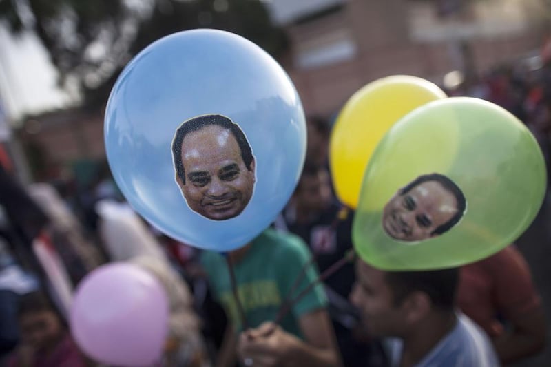 Egyptians hold balloons bearing portraits of ex-army chief Abdel Fattah al-Sisi as they celebrate in front of the presidential palace of Ethadya in the capital Cairo.  Mahmoud Khaled / AFP