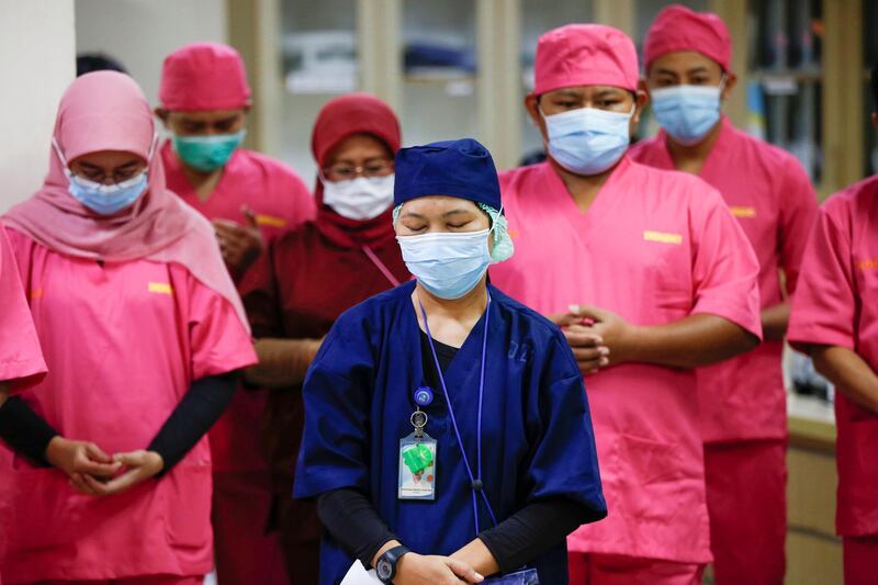 Healthcare workers pray for patients during a briefing in the emergency room at Persahabatan Hospital in Jakarta, Indonesia, May 14. Willy Kurniawan / Reuters