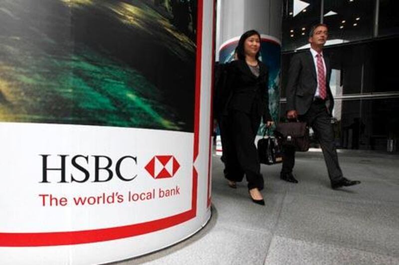 People walk past the entrance to HSBC headquarters in Hong Kong May 11, 2011. HSBC is to streamline its wealth management business, retreat from retail banking in some countries and may sell its U.S. credit cards arm as new CEO Stuart Gulliver attempts to cut $3.5 billion in costs and revive flagging profits.    REUTERS/Bobby Yip   (CHINA - Tags: BUSINESS)