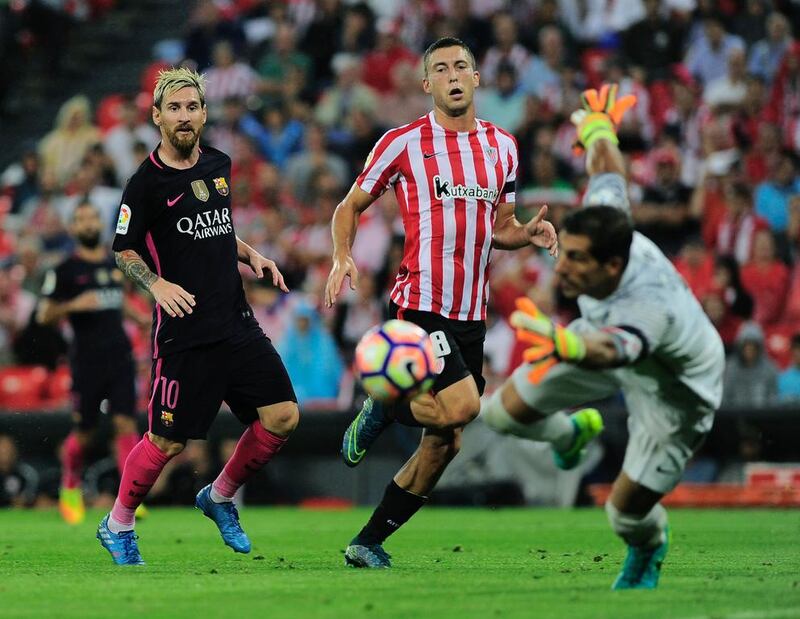 Barcelona’s Lionel Messi, left, and teammate defender Jordi Alba eye the ball. Ander Gillenea / AFP