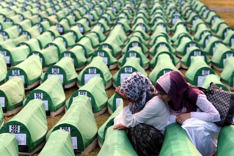 Bosnian Muslim women mourn over a casket during the funeral of 775 newly-identified Bosnian Muslims at the Potocari Memorial Center in Srebrenica, Bosnia and Herzegovina, July, 11, 2010. EPA