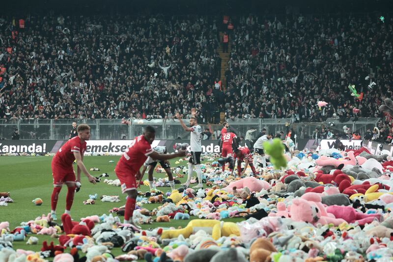 Players from Besiktas and Antalyaspor move toys to side of pitch after fans threw them down from stands at Vodafone Park in Istanbul on February 26, 2023, in support of children affected by the recent earthquakes in Turkey and Syria. Reuters