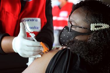 Ashia Rivers, 17, of Havre De Grace, Maryland, US gets her first dose of the Pfizer vaccine against the coronavirus while sitting in the back seat of her family car at the mass vaccination site at Ripken Baseball on May 05, 2021 in Aberdeen, Maryland, US. Getty Images/AFP