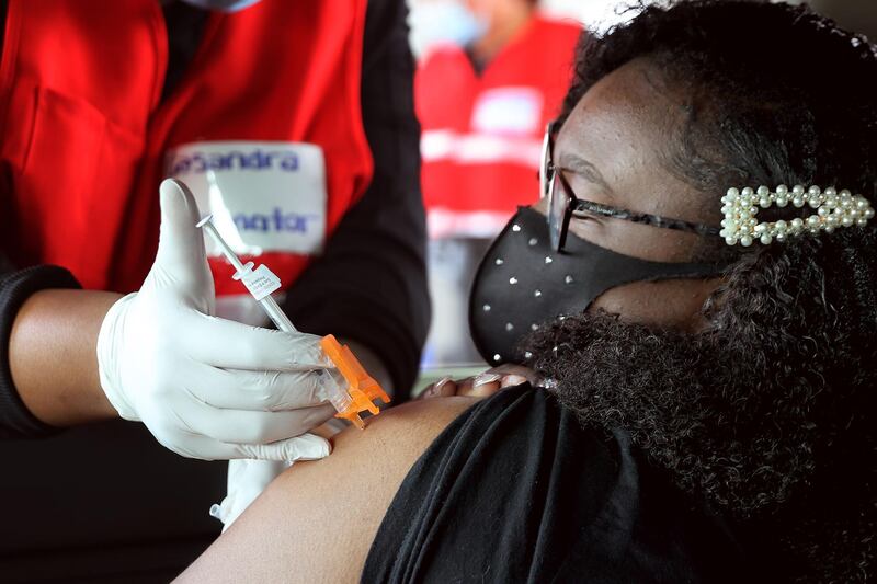 ABERDEEN, MD - MAY 05: Ashia Rivers, 17, of Havre De Grace, Maryland, gets her first dose of the Pfizer vaccine against the coronavirus while sitting in the back seat of her family car at the mass vaccination site at Ripken Baseball on May 05, 2021 in Aberdeen, Maryland. Maryland Governor Larry Hogan announced that more than 5 million people in Maryland have now received their first dose of the COVID-19 vaccine.   Chip Somodevilla/Getty Images/AFP
== FOR NEWSPAPERS, INTERNET, TELCOS & TELEVISION USE ONLY ==
