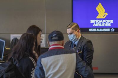 LOS ANGELES, CA - FEBRUARY 02: A Singapore Airlines employee wears a medical mask for protection against the novel coronavirus outbreak at LAX Tom Bradley International Terminal on February 2, 2020 in Los Angeles, California. The United States has declared a public health emergency and will implement strict travel restrictions later today. Foreign nationals who have been in China in the last two weeks and are not immediate family members of U.S. citizens or permanent residents will be barred from entering the U.S. Meanwhile, about 195 U.S. citizens who were evacuated from China to March Air Reserve in California are under under quarantine at the base, prohibited from leaving until it is determined that they will not develop symptoms of the disease.   David McNew/Getty Images/AFP
== FOR NEWSPAPERS, INTERNET, TELCOS & TELEVISION USE ONLY ==
