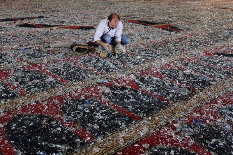 A man removes broken glass scattered on the carpet of a mosque damaged in Tuesday's blast in Beirut. Reuters