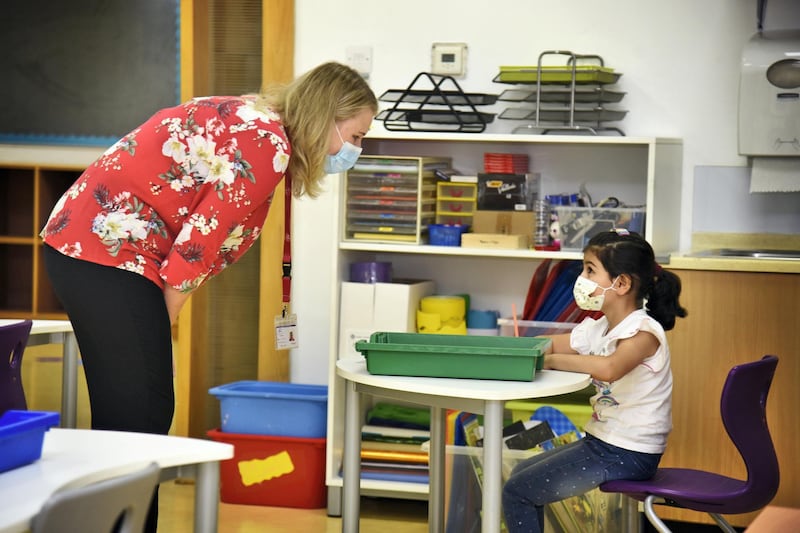 Tarryn Patel, a homeroom teacher from South Africa, attends to her grade 1 student at the Al-Mizhar American Academy after the government re-opens schools in the wake of the Covid-19 pandemic, in Dubai, UAE, Sunday, Aug. 30, 2020. (Photos by Shruti Jain - The National)