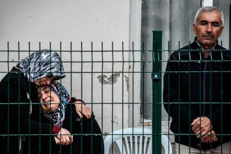 A mother, centre, of a victim cries as she waits for the body of her son at the forensic building in Ankara the day after a suicide car bomb ripped through a busy square. Ozan Kose / AFP