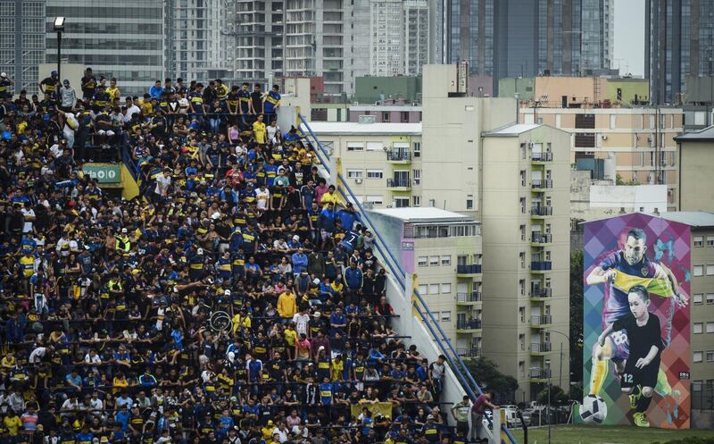 Boca Juniors fans pack the stands inside La Bombonera as a mural of Carlos Tevez appears in the backdrop. Getty Images