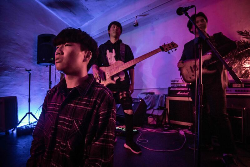 In a photo taken on November 10, 2019 members of post hardcore metal band Monsters Dive Chu Yeonsik, Kim Daesik, and Dominic Jin rest between songs during their set at a venue in Seoul. AFP