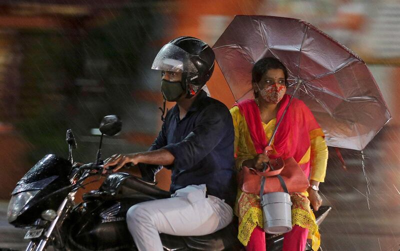 People ride a motorcycle in the rain in Hyderabad, India. AP Photo