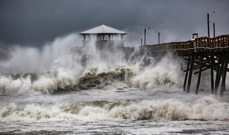 Waves slam the Oceana Pier and Pier House Restaurant in Atlantic Beach, North Carolina.  Travis Long / The News & Observer via AP