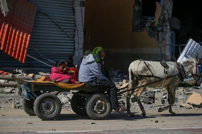 A Palestinian family pass through the devastation of Al Nuseirat refugee camp, in central Gaza. EPA