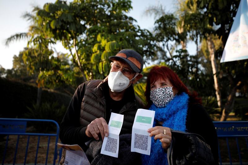 Israelis display their ‘Green Pass’, proof of vaccination or immunity against the coronavirus, at the entrance to a performance by singer Nurit Galron at Yarkon Park in Tel Aviv.