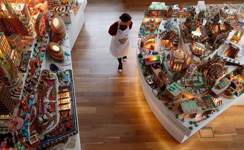 A staff member poses for a photograph next to the Museum of Architecture's Gingerbread City at the V&&A Museum, London. Reuters