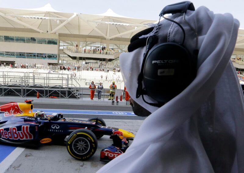 A journalist watches Red Bull driver Sebastian Vettel of Germany as he steers his car back to pits during the third free practice at the Yas Marina racetrack, in Abu Dhabi, United Arab Emirates, Saturday, Nov. 3, 2012. The Emirates Formula One Grand Prix will take place on Sunday. (AP Photo/Luca Bruno) *** Local Caption ***  Mideast Emirates F1 GP Auto Racing.JPEG-0c9f0.jpg