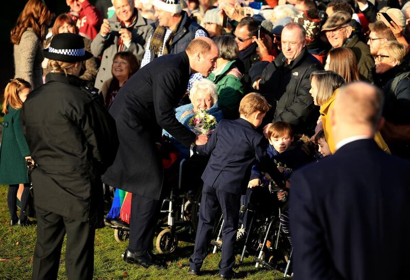 Britain's Prince William, Duke of Cambridge and his son Prince George greet the public after attending a Christmas day service at the St Mary Magdalene Church in Sandringham. AP
