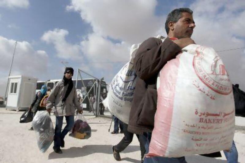 Syrian refugees carry their belongings to the new Jordanian-Emirati refugee camp, Mrajeeb Al Fhood, in Zarqa. The camp is the first Syrian refugee camp to be funded by the UAE and is run by the Red Crescent Society.