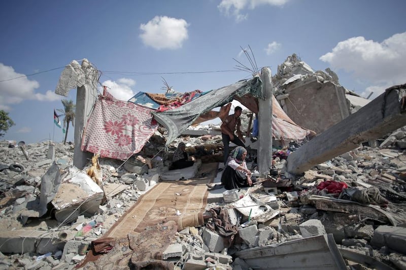 A Palestinian family shelters amid the rubble of their destroyed house in the town of Khan Younis in the southern Gaza Strip. The need for new homes is chronic and unrelenting. Khalil Hamra / AP
