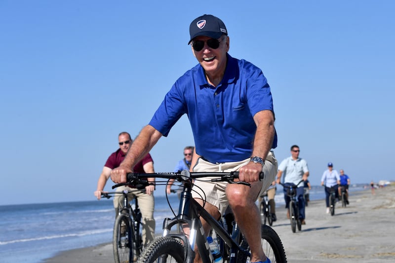 Mr Biden and a pack of Secret Service agents take a beach ride. AFP