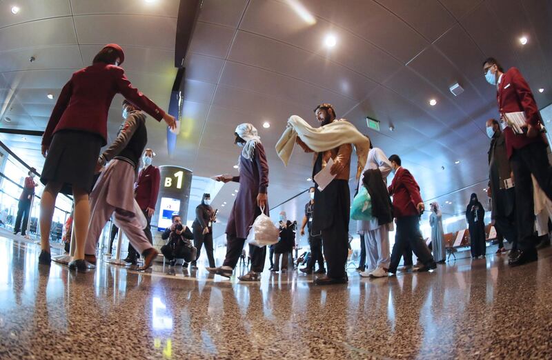 A picture taken with a fisheye lens shows passengers heading to the waiting lounge at the departure hall of Qatar's Hamad International Airport near Doha as the first commercial flight to Saudi Arabia in three and a half years prepared to take off following a Gulf diplomatic thaw.  AFP