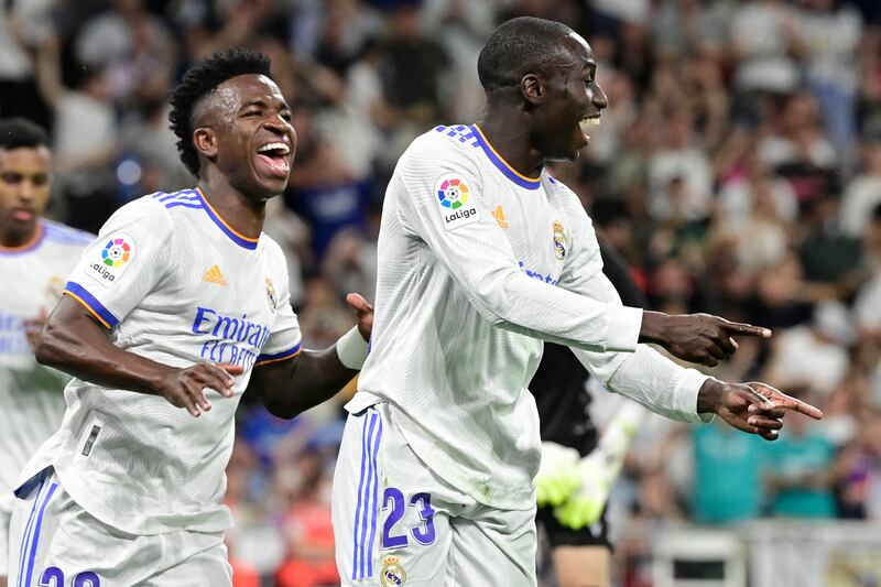 Real Madrid's French defender Ferland Mendy (R) celebrates with forward Vinicius Junior after scoring the opening goal in the 6-0 La Liga win against Levante at the Santiago Bernabeu on May 12, 2022. AFP