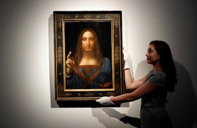 FILE - In this Oct. 24, 2017 file photo, an employee poses with Leonardo da Vinci's "Salvator Mundi" on display at Christie's auction rooms in London.  Abu Dhabiâ€™s Department of Culture and Tourism announced Wednesday June 27, 2018,  that Leonardo da Vinciâ€™s Renaissance oil painting of Christ 'Salvator Mundi' will be put on display at The Louvre Abu Dhabi from Sept. 18. (AP Photo/Kirsty Wigglesworth, File)