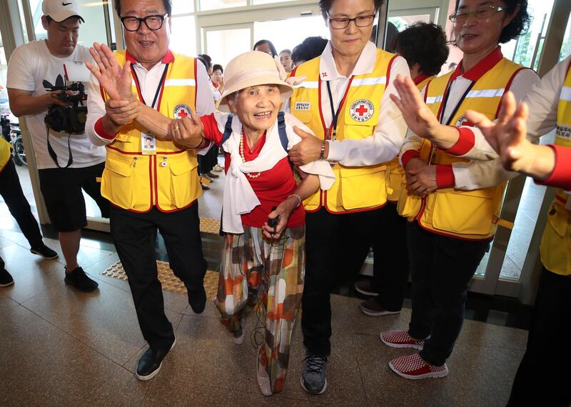 South Korean Lee Geum-seom, 92, second from left, is helped by Red Cross officials as she arrives to take part in family reunions with her North Korean family members at a hotel in Sokcho, South Korea. AP