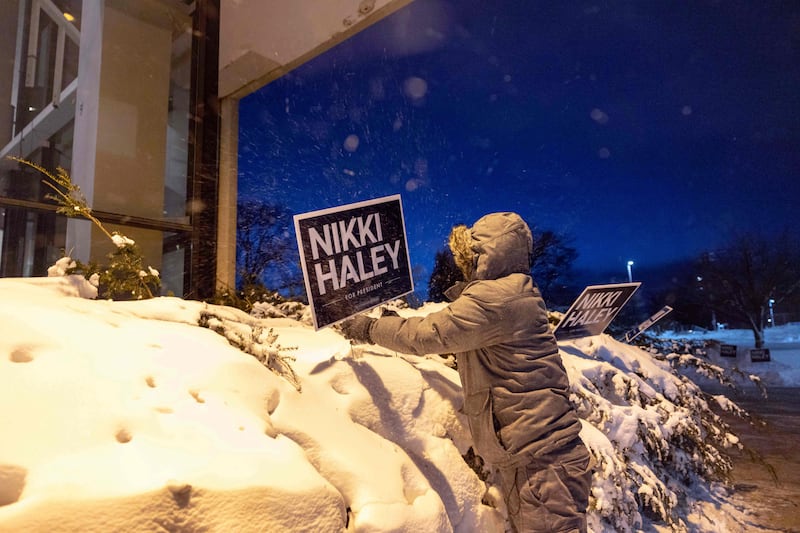 A campaign staffer member plants signs supporting Ms Haley at Franklin Jr High School in Des Moines. AFP