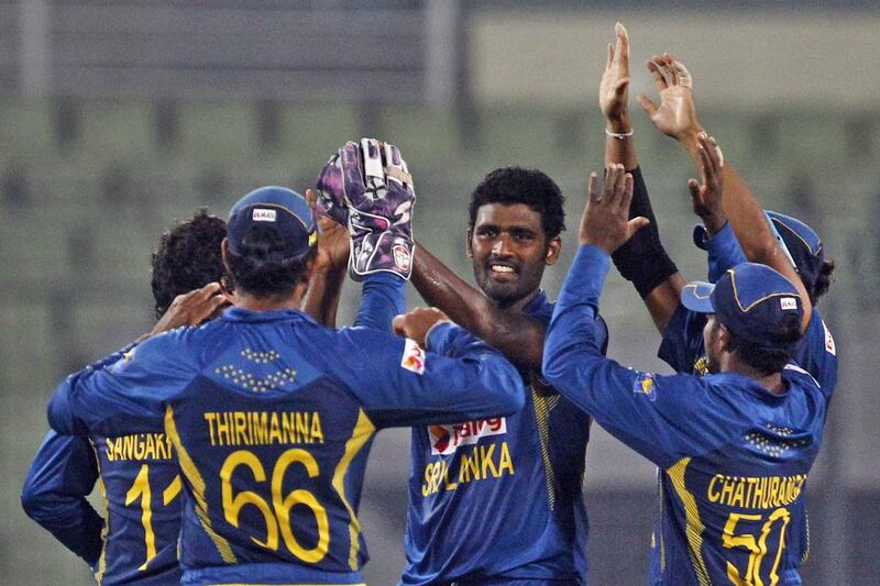 Sri Lanka’s Thisara Perera, centre, celebrates with teammates after taking the wicket of Afghanistan’s Nawroz Mangal during their Asia Cup match in Dhaka, Bangladesh, on March 3, 2014. A M Ahad / AP Photo