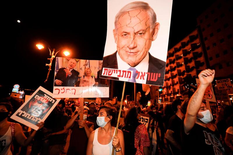 Protesters chant slogans during a demonstration of thousands against the Israeli government near the Prime Minister's residence in Jerusalem on August 2, 2020. Thousands protested against Prime Minister Benjamin Netanyahu across Israel on Saturday night, demanding he resign over alleged corruption and a resurgence of coronavirus cases. / AFP / MENAHEM KAHANA
