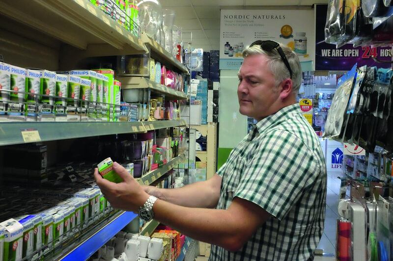 Kevin Hackett assesses lightbulbs at Al Maya supermarket in Dubai Marina. Jaime Puebla / The National